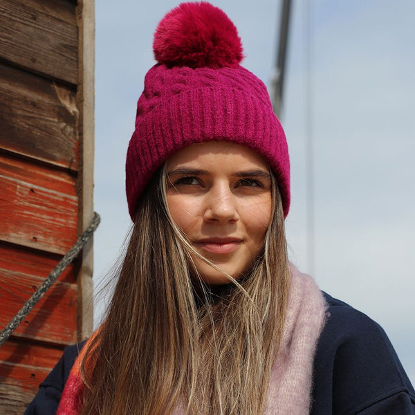 50% recycled magenta cable knit and faux fur bobble hat